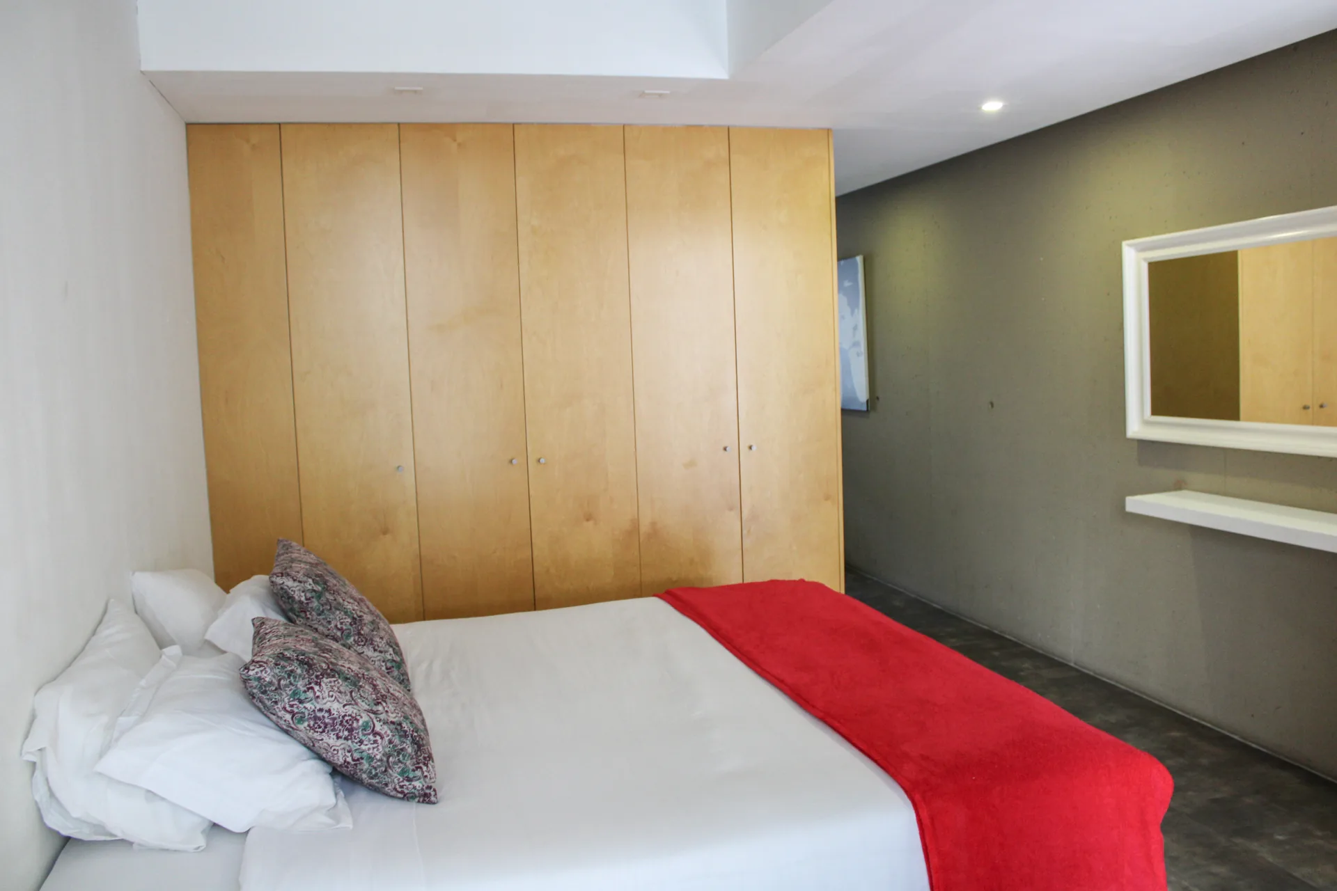 Quarto do Urban Master com cama king size e colcha vermelha