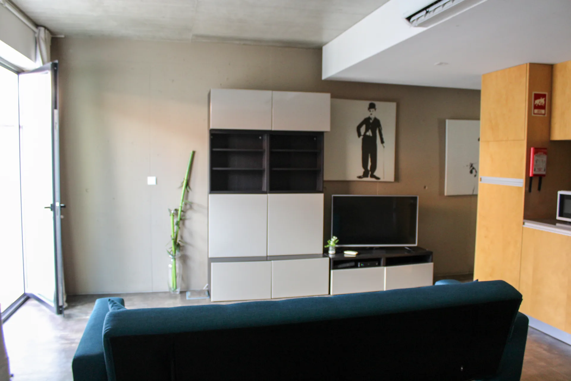 Sala de estar do Urban Master com sofá e televisão, junto à janela