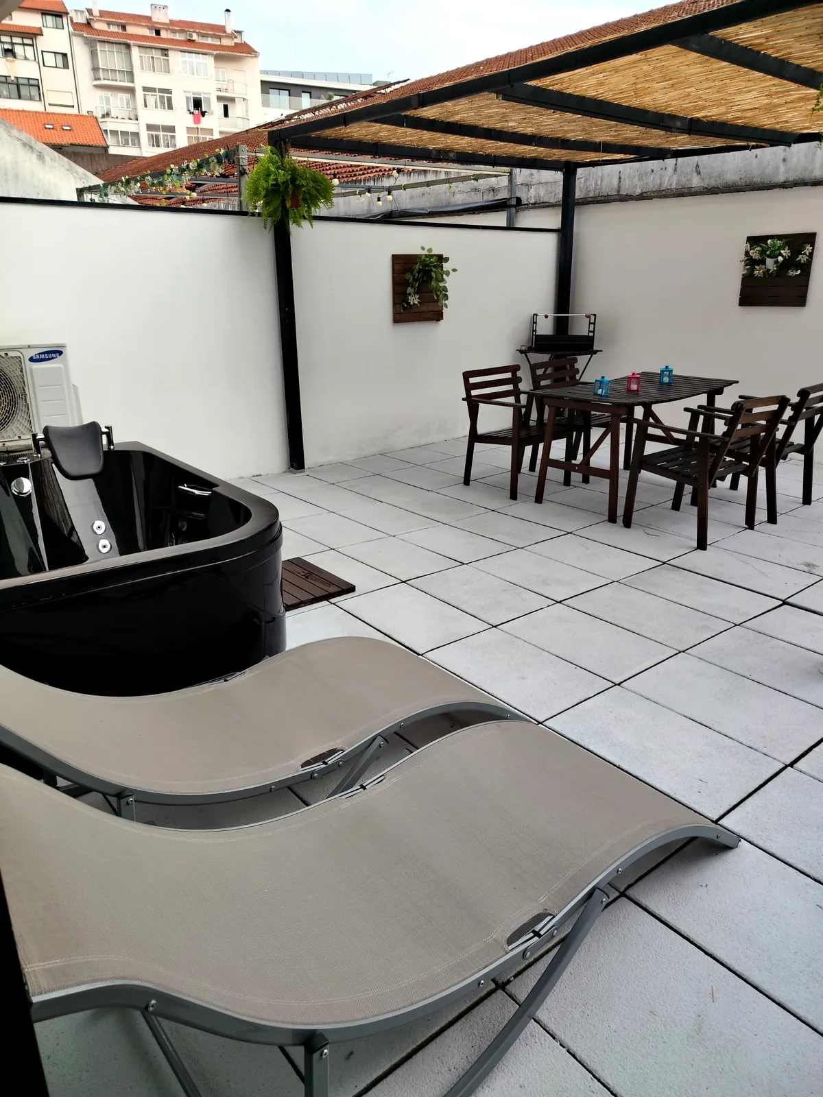 Terraço privado do Urban Master em Aveiro com jacuzzi, espreguiçadeiras e mesa sob a pérgola